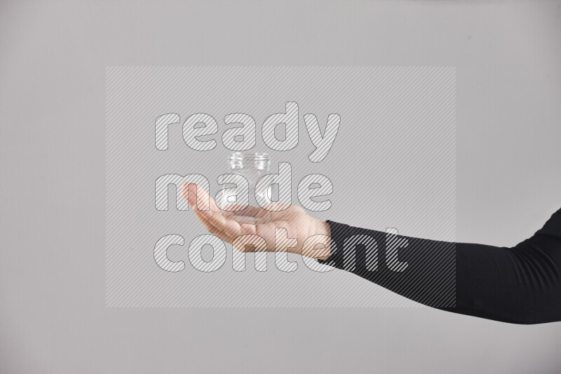 A woman in black abaya holding different glassware in different positions