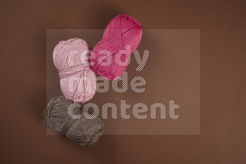 مجموعة من أدوات الخياطة والتفصيل زهرية اللون على خلفية بنية