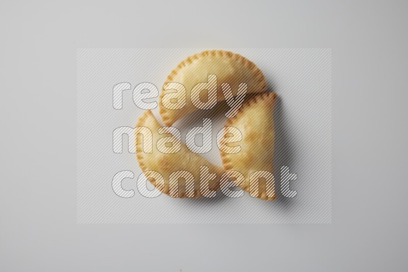 Three fried sambosa from a top angle on a white background
