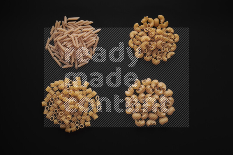 Different pasta types in bunches on black background