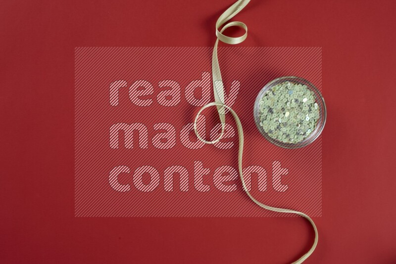 A green and red collection of sewing and tailoring tools arranged on a red background
