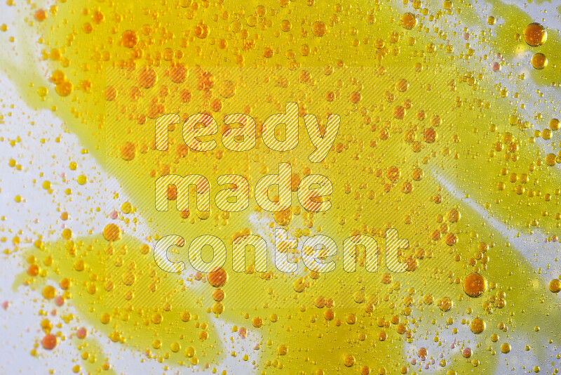 Close-ups of abstract yellow and red watercolor drops on oil Surface on white background