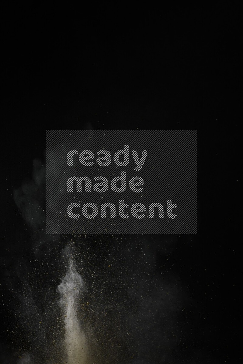 A side view of yellow powder explosion on black background
