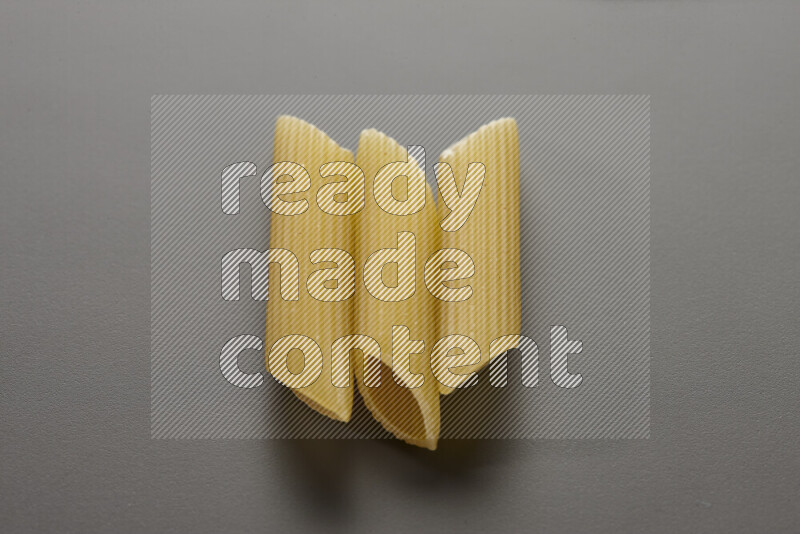 Penne pasta on grey background