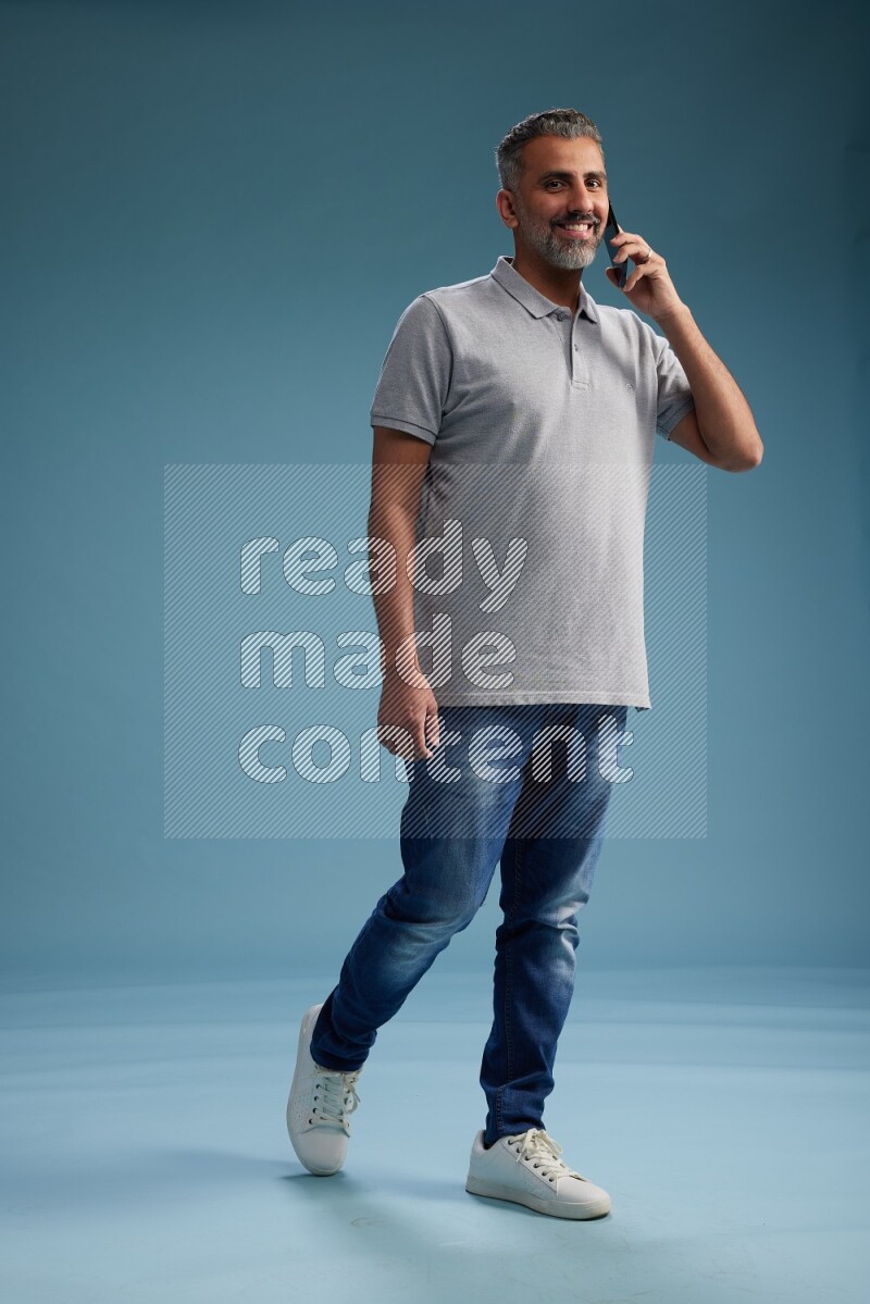 Man Standing talking on phone on blue background