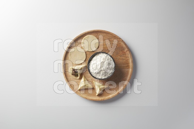 two closed sambosas and one open sambosa filled with meat while flour aside in a wooden dish on a white background