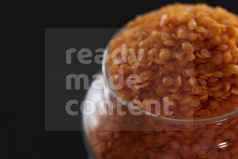Lentils in a glass jar on black background