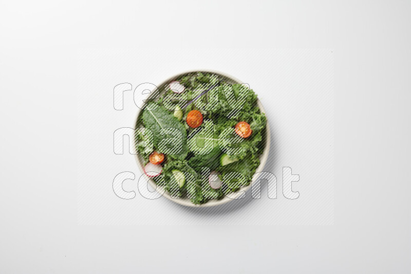 A bowl of fresh vegetables salad with kale leaves, cherry tomatoes, sliced radishes and sliced cucumber on a white background