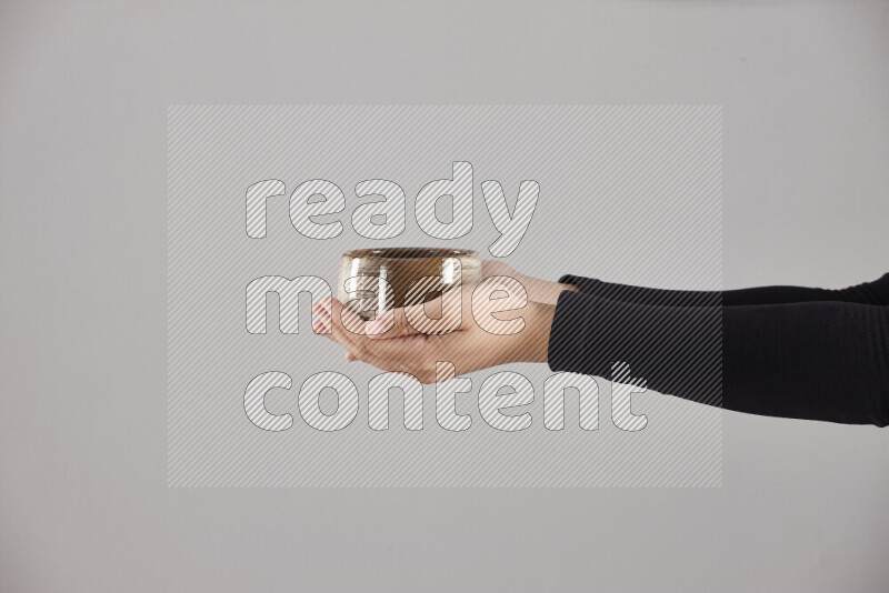 A woman in black abaya holding different pottery essentials in different positions