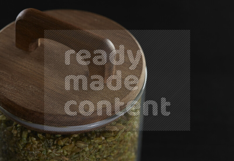 Freekeh in a glass jar on black background
