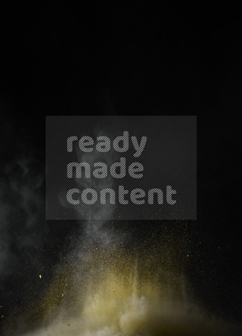 A side view of yellow powder explosion on black background