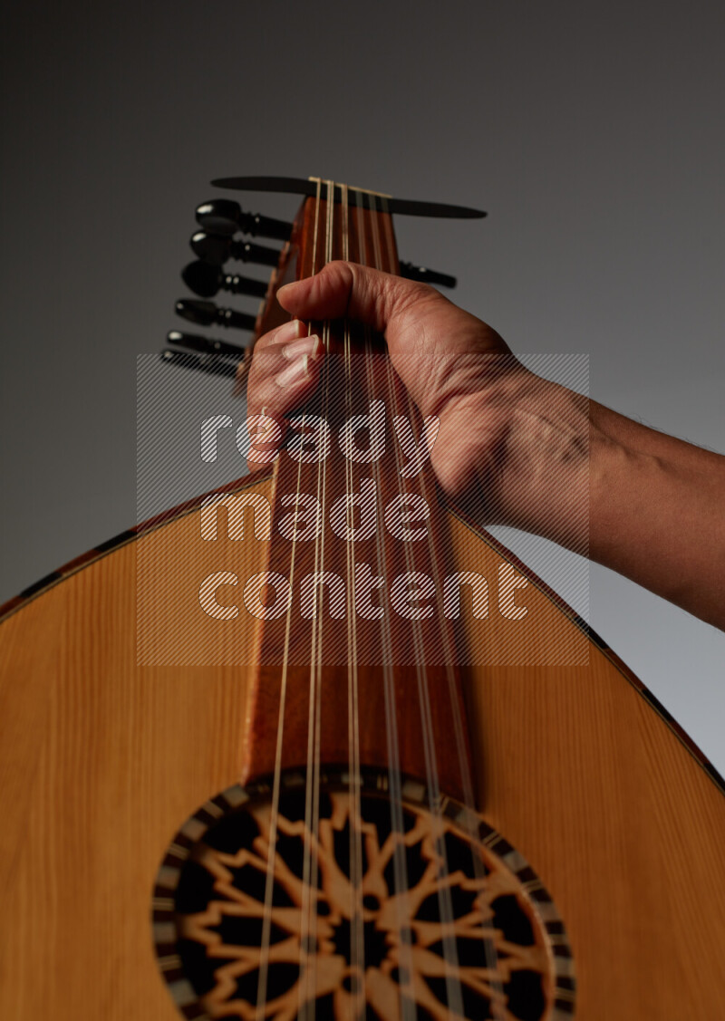 يد رجل تعزف على عود خشبي بني