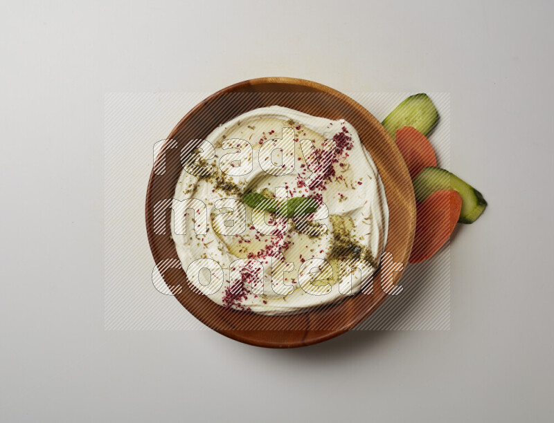 Lebnah garnished with  zattar , sumak & mint in a wooden plate on a white background