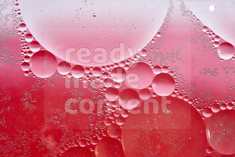 Close-ups of abstract oil bubbles on water surface in shades of white, red and pink