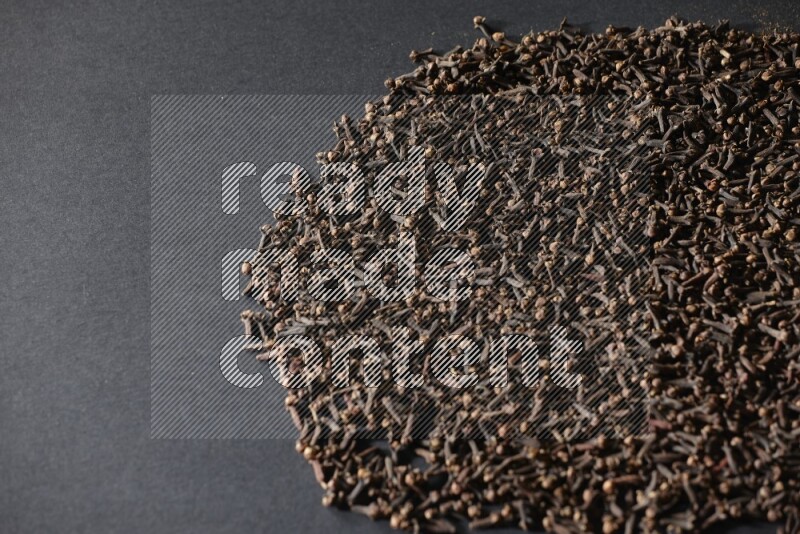 Cloves spread on black flooring