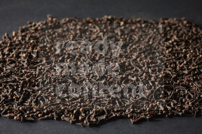 Cloves spread on black flooring