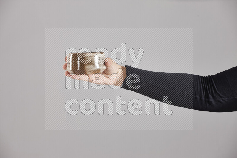 امرأة ترتدي عباءة سوداء تحمل أدوات فخارية مختلفة في أوضاع متعددة