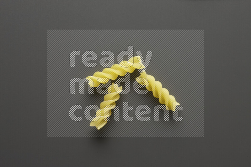 Fusilli pasta on grey background