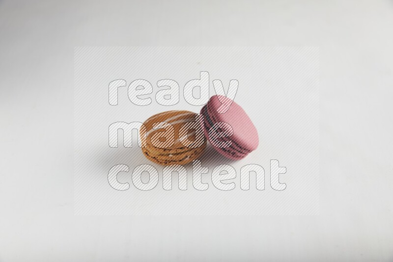 45º Shot of of two assorted Brown Irish Cream, and Red Cherry macarons on white background