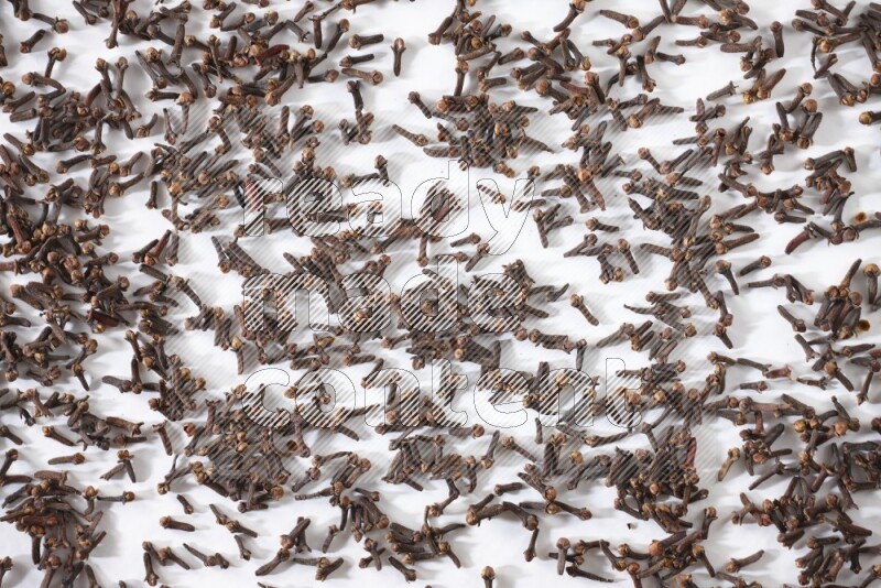 Cloves spread on white flooring