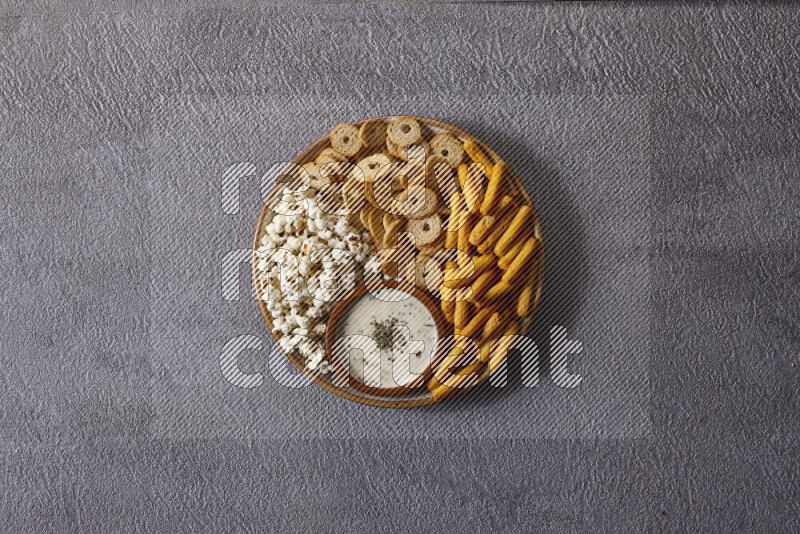 Assorted snacks in pottery bowls on grey background