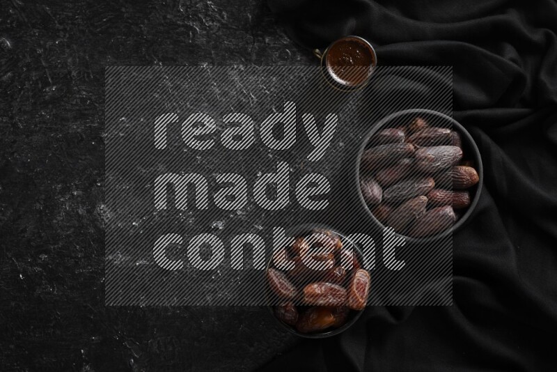 تمر في أوعية فخارية مع القهوة علي خلفية سوداء خشبية