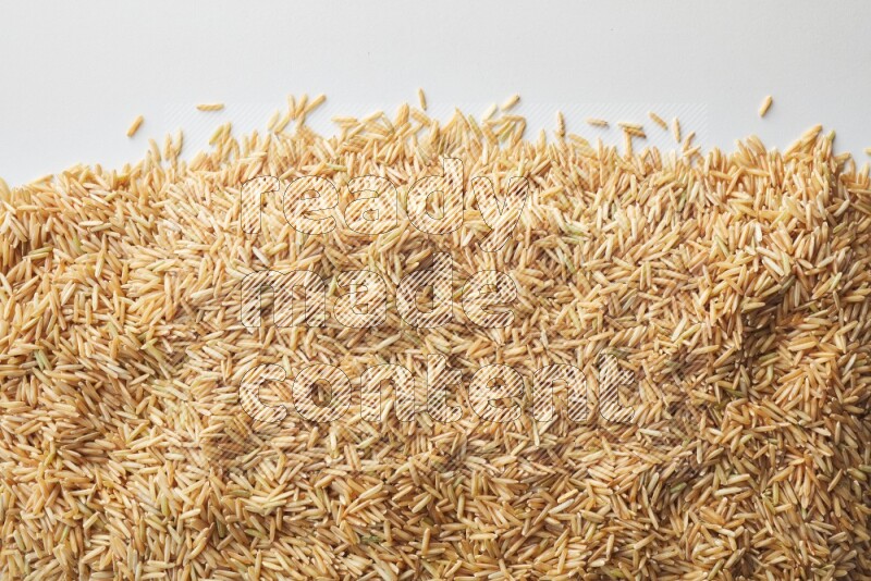 Top-view shot of long grain brown rice on white background
