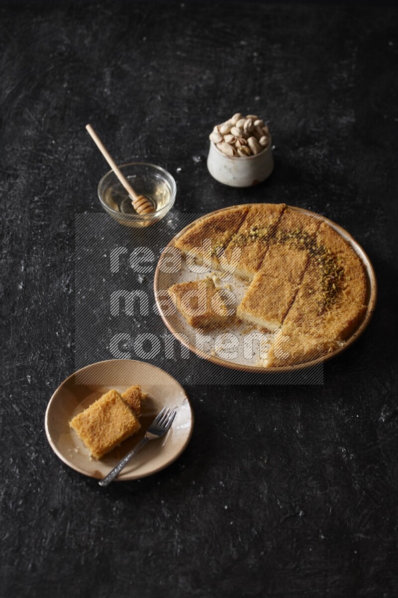 Konafa with nuts and honey in a dark setup