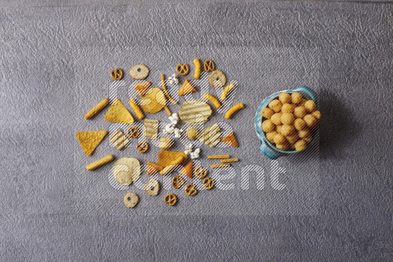 Assorted snacks in pottery bowls on grey background