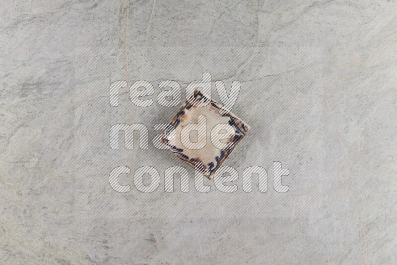 A decorative pottery plate on grey marble background