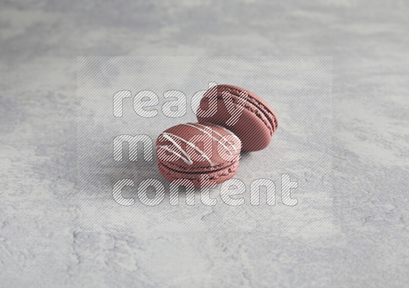 45º Shot of two Red Poppy Flower macarons on white  marble background