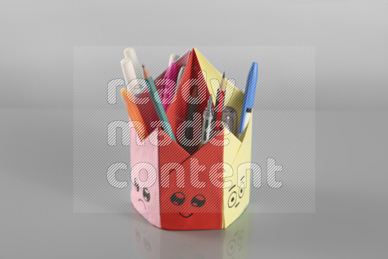 Origami pen holder on grey background