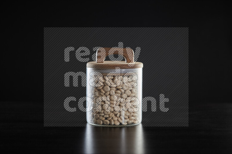 Lupin Beans in a glass jar on black background