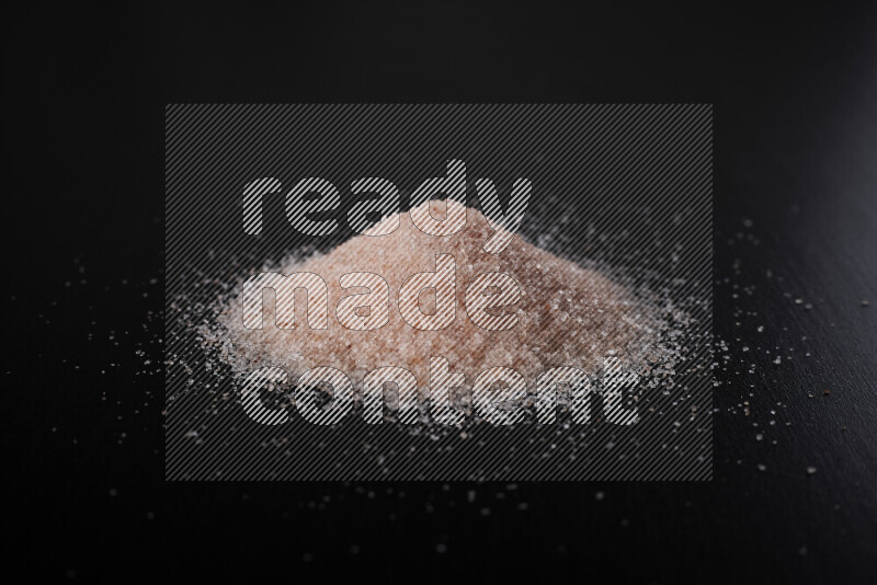 A bunch of fine himalayan pink salt on black background