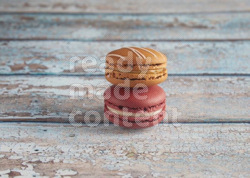 45º Shot of of two assorted Brown Irish Cream, and Red Velvet macarons on light blue background