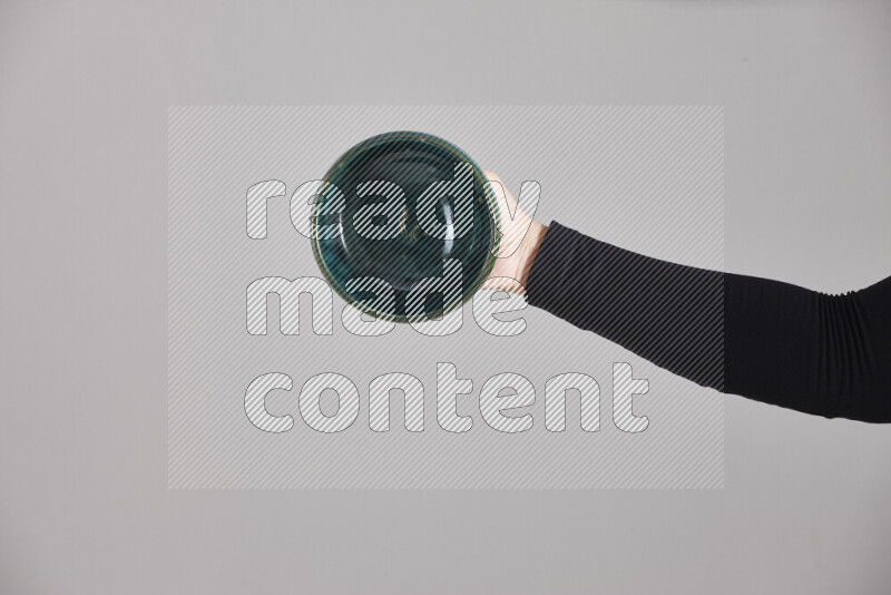 امرأة ترتدي عباءة سوداء تحمل أدوات فخارية مختلفة في أوضاع متعددة