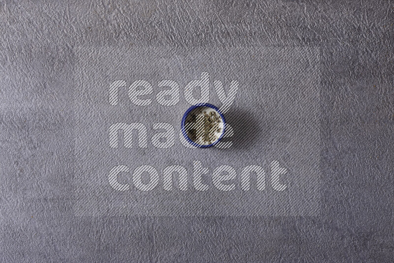 Assorted snacks in pottery bowls on grey background