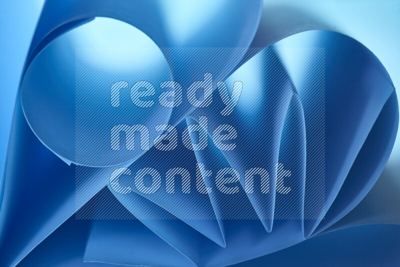 عرض فني لطيات الورق تخلق مزيج من الأشكال الهندسية، مضاءة بإضاءة ناعمة بدرجات اللون الأزرق