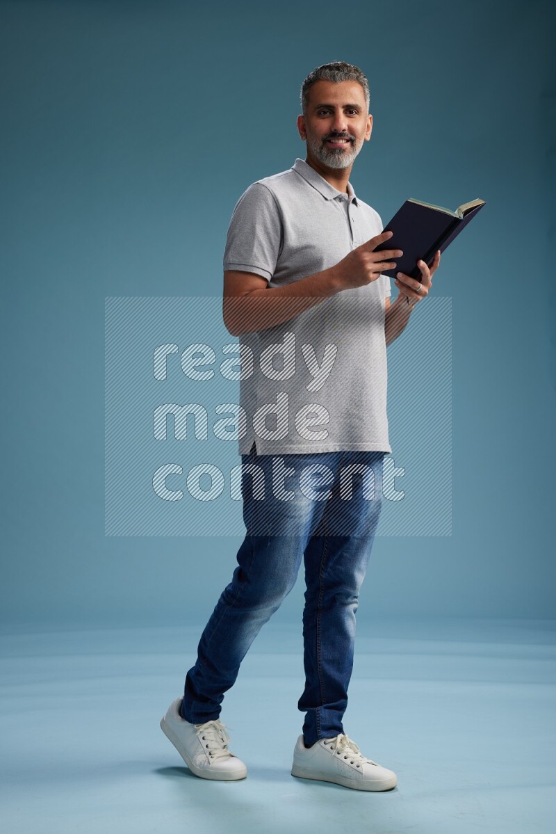 Man Standing reading book on blue background