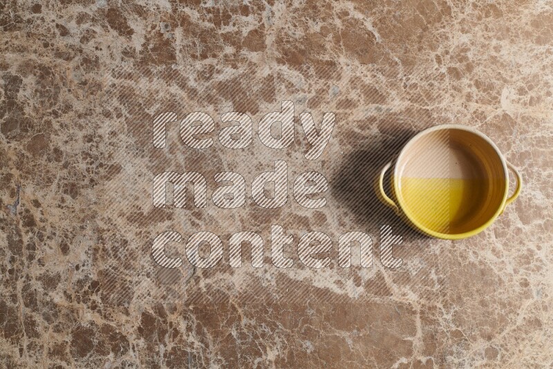 A multicolored pottery bowl on beige marble background