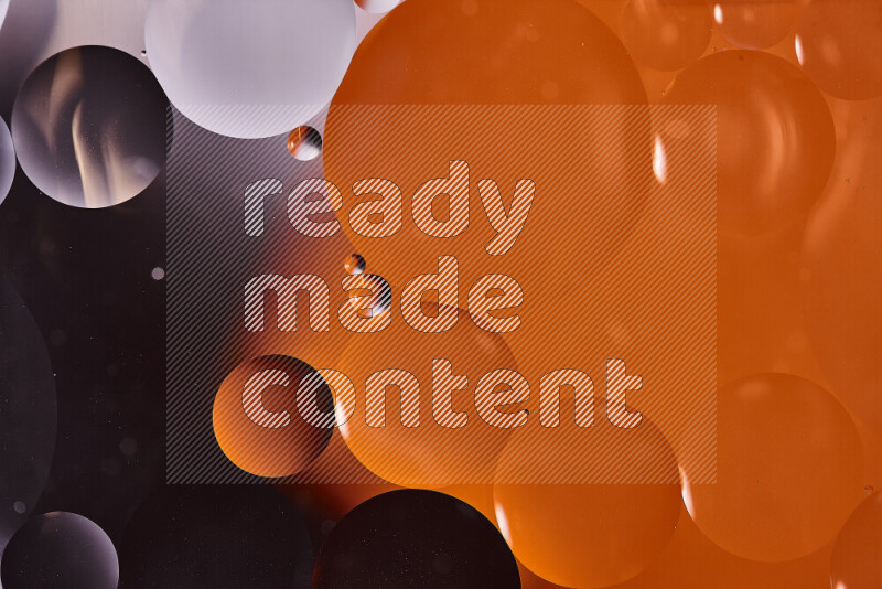 لقطات مقربة لفقاعات من الزيت على سطح الماء باللون الأسود والبرتقالي