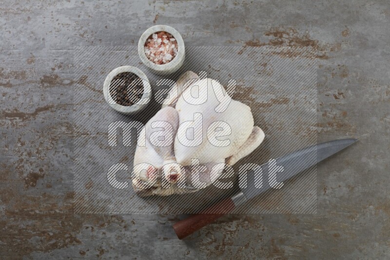 whole raw chicken  direct on a rustic grey background