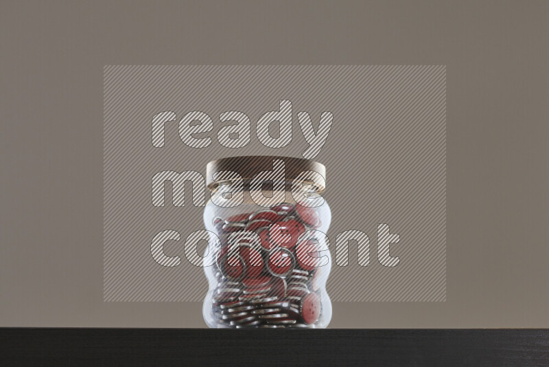 Buttons in a glass jar on black background