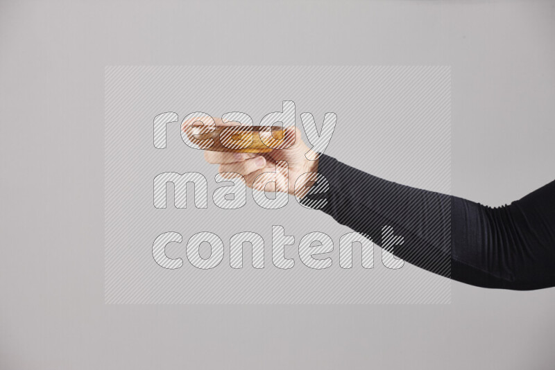 امرأة ترتدي عباءة سوداء تحمل أدوات خشبية مختلفة في أوضاع متعددة