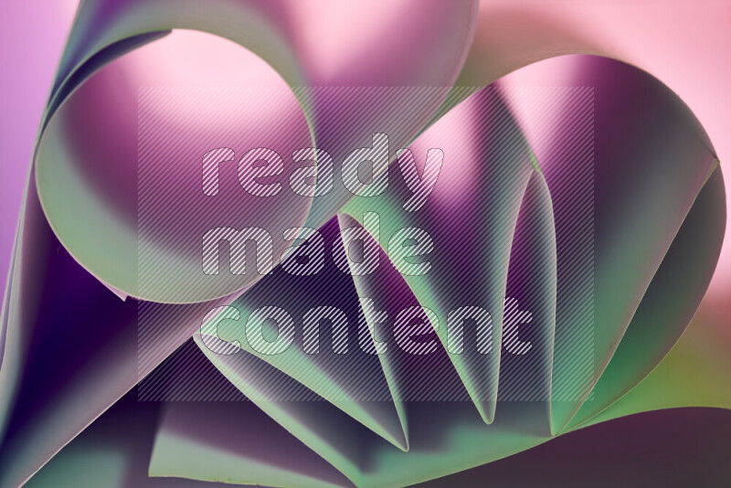 عرض فني لطيات الورق تخلق مزيج من الأشكال الهندسية، مضاءة بإضاءة ناعمة بدرجات اللون الأخضر والارجواني