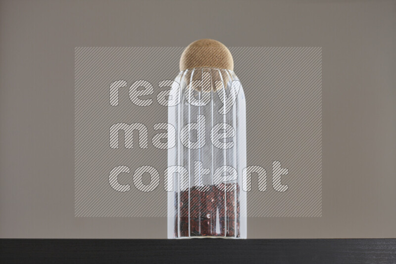 Sequins in a glass jar on black background