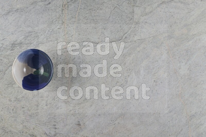 A multicolored pottery Bowl on grey marble background