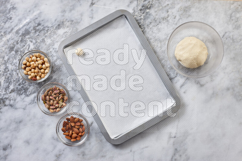 Ghoriba step by step with its ingredient, flour, powdered sugar, ghee and nuts on grey marble background