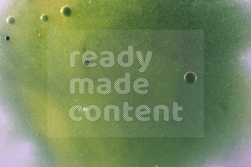 Close-ups of abstract yellow, blue and green watercolor drops on oil Surface on white background