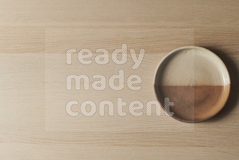A multicolored pottery oven plate on light wooden background
